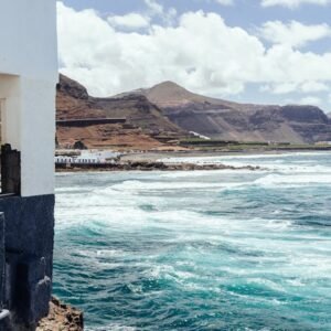 Breathtaking coastal view of Gran Canaria with waves hitting the shore under a sunny sky.