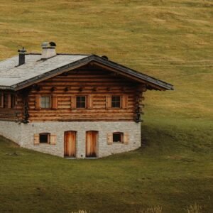 Charming rustic log cabin nestled in lush green hills, perfect for countryside retreats.